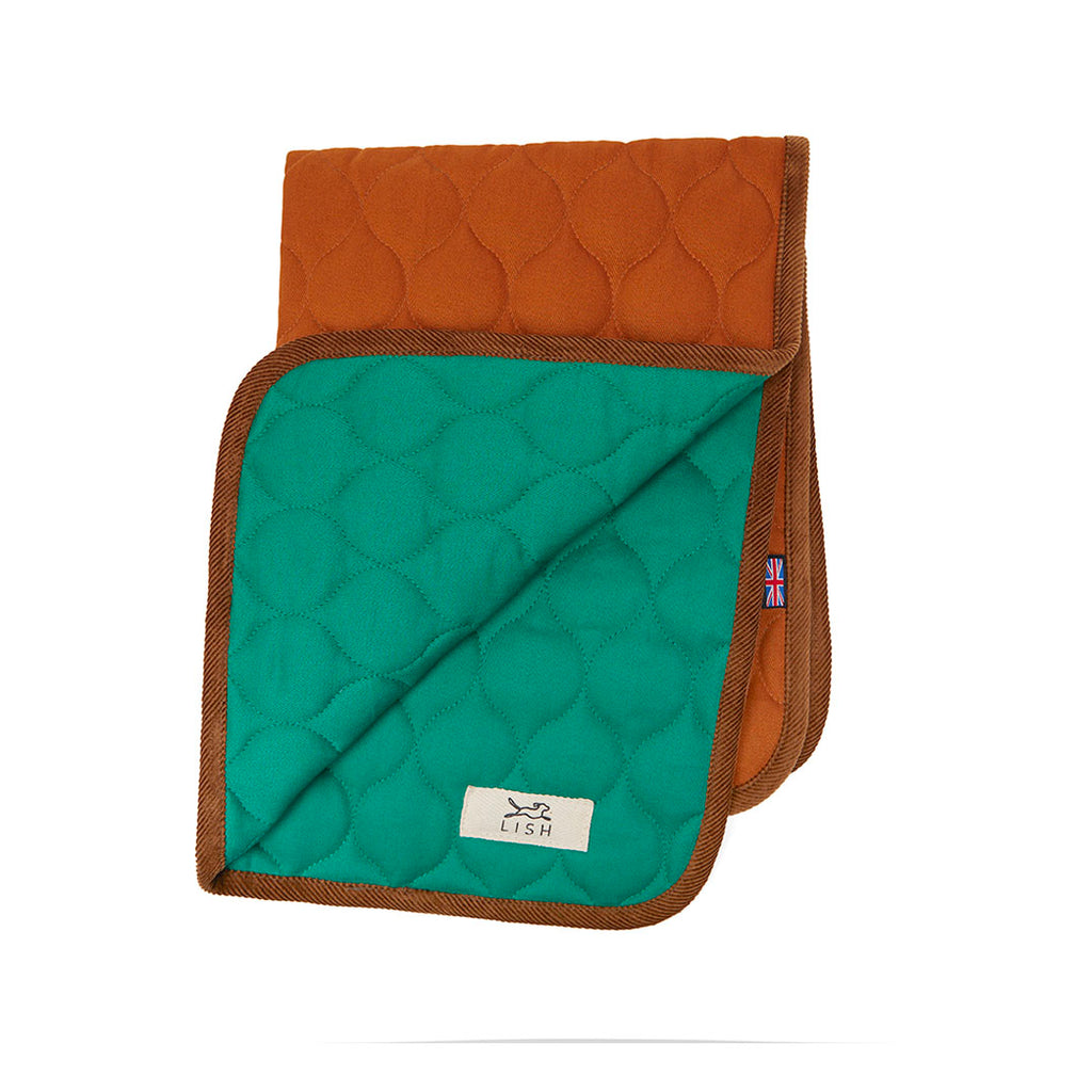The Winkley Pea Green Cotton Designer Pet Travel Blanket, is made with eco friendly cotton and handcrafted in England. Double layered reversible luxury dog blanket quilted using recycled fibres dual sided folded open